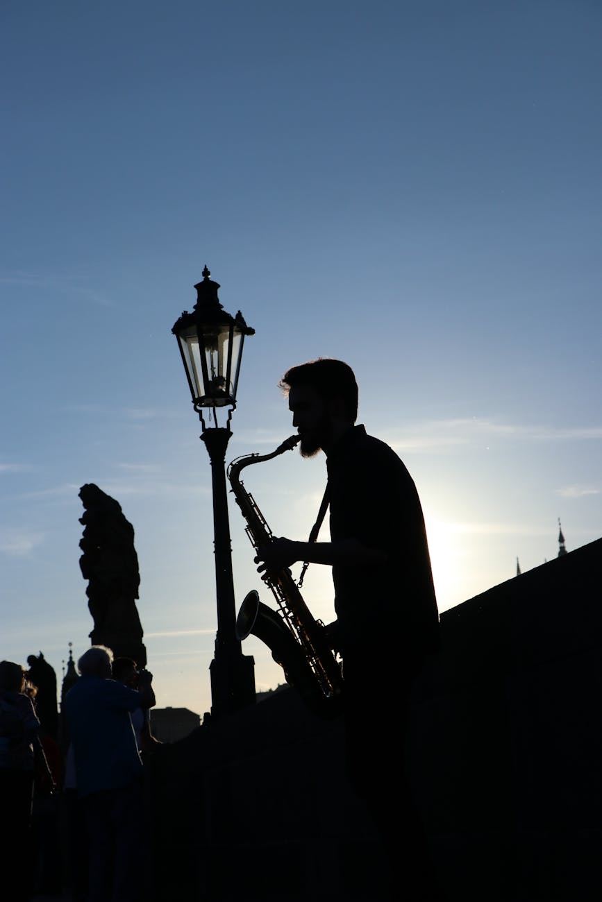 Top 4 Prague Music Venues in the City Center for Rock, Classical, Jazz & Pop 1 silhouette of a man playing the saxophone on the street
